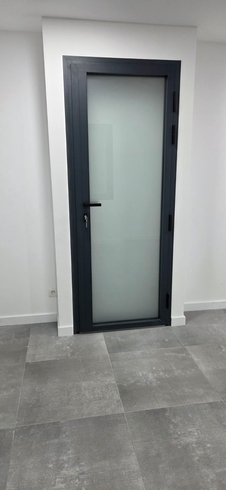 Porte aluminium anthracite exposée au showroom SPMC Menuiserie