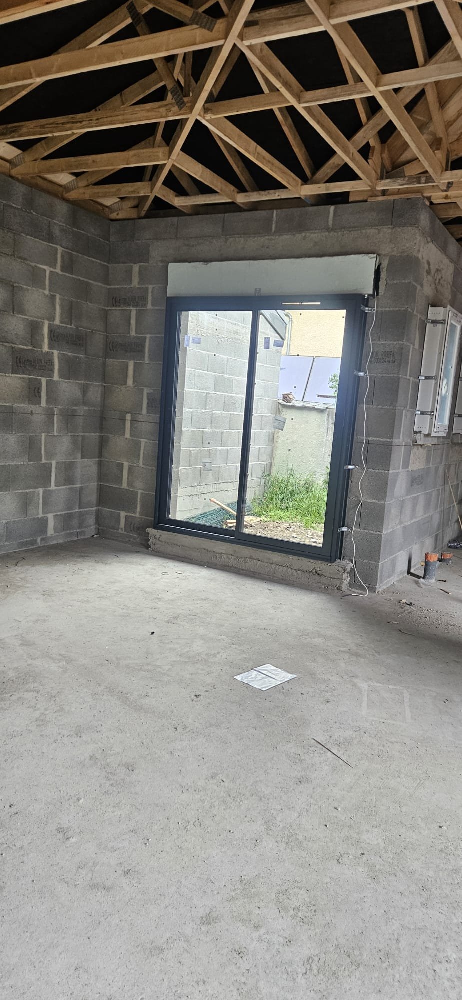 Baie coulissante aluminium posée dans une maison neuve en construction